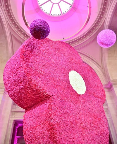 Towering above the Information Desk at the center of the Met’s Great Hall was a 30-foot-tall violet design made of hot-pink roses with white roses at the center. Solid color balls made from white, pink, and hot-pink or burgundy roses, measuring five feet in diameter, hung from the ceiling or sat on the floor.