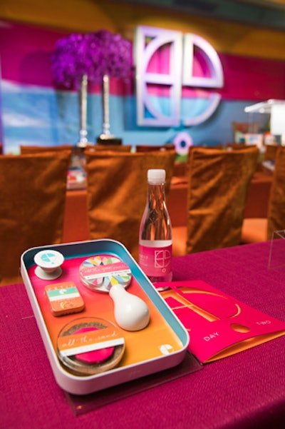 An on-theme desktop gift included a magnetic tray with branded items attached, including a mini vase, colorful sticky notes, a mint tin, kinetic sand with a press, and a pop socket for the guest's phone.