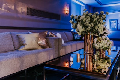 Low couches with metallic pillows along the sides of the ballroom created lounge-like spaces for guests.