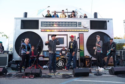 A massive boombox served as the backdrop for a hip-hop band and DJ at the Block Party on the first night of the conference. The event included additional entertainment, an arcade, a virtual-reality movie experience, food, and more.