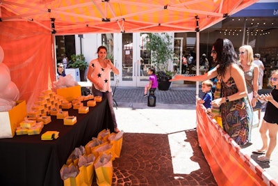 Bracelet Toss participants stood behind a barrier and tossed a Kendra Scott bracelet three times to try to land it inside boxes arrayed on a table. Anyone who made it in twice won a bracelet.