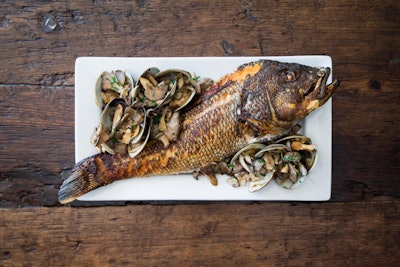 Crispy skin striped bass topped with a sauce of leeks, wellfleet clams, vermouth, and wild mushrooms, by Season to Taste Catering in Cambridge, Massachusetts