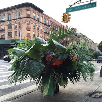 A lush, tropical floral arrangement, which was located at the corner of 116th Street and Frederick Douglass Boulevard, featured giant palm leaves and bright orange blooms.