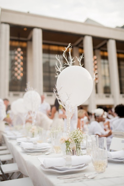 The centerpieces included three-foot-tall white trees from Shop Wild Things wrapped in LED lights and baby’s breath with roses in bud vases.