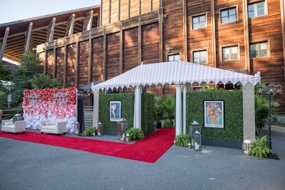 Oversize graphic roses in a red, pink, and white ombre colors covered the step-and-repeat, which was moved inside during the dinner for photo ops.