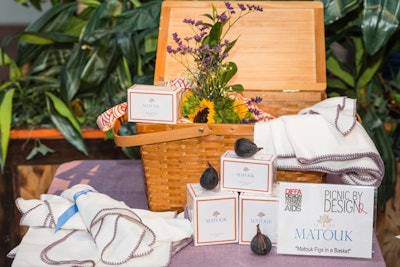Linen purveyor Matouk put a spotlight on a purple sample of new table coverings by using figs and lemon fig verbena candles for its basket.
