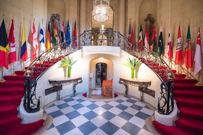 Flags of embassies hosting pre-Ball dinners flank the grand staircase in the foyer of Meridian House.
