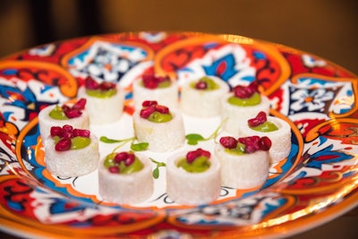 Served on colorful plates, passed appetizers included jicama cups with guacamole and pomegranate seeds from Design Cuisine.