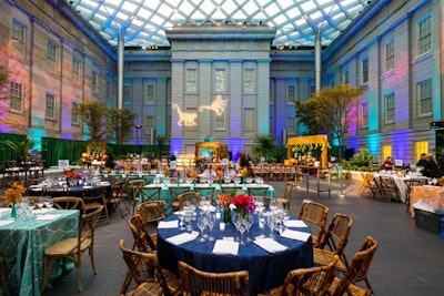 The evening featured a mix of rectangular and round tables with brightly colored linens. Projections of monkeys on the wall tied the room into the gala's theme.