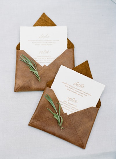 Boutique graphic design firm Yonder in San Francisco uses unconventional materials like marble, mother of pearl, rare leathers, and woods to create luxe stationery suites, menus, and more. Examples of work include an invitation constructed with pieces of clear acrylic filled with wild moss and a letterpressed menu nestled in a custom leather envelope with a sprig of rosemary.