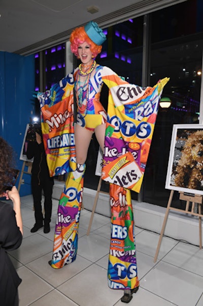 A stilt dancer dressed in a colorful candy wrapper-inspired costume entertained guests.