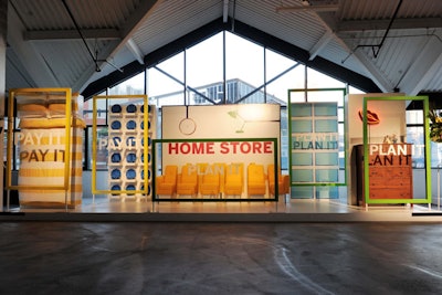 The home store-theme installation featured yellow chairs for guests to pose, as well as a bed, blue plates, a dresser, and neon lips.