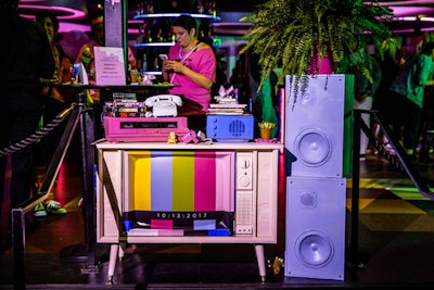 'We were able to take people’s old junk and turn it into a decor element, which then turned into photo ops for all our guests,' said Blasioli. A vintage TV set display included rainbow graphics on the screen, and props including purple stereos, a pink cassette player, VHS tapes, and a rotary dial phone.
