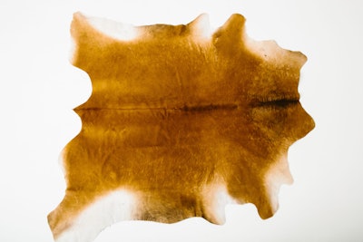 A cozy caramel cowhide rug is available in San Francisco from Yeah Rentals. Pricing is available upon request.