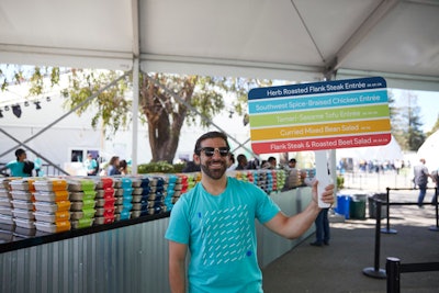 Staff held color-coded menu signs to improve attendee flow through the food area.