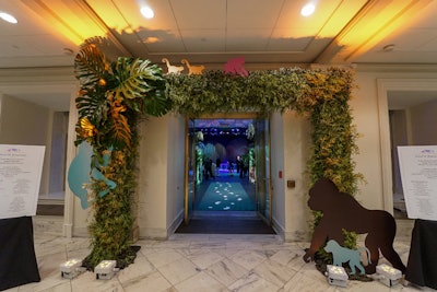 An archway tying into the monkey-business theme was created with echoes of the primates that appeared on the event's invitation. Maintaining their colors, the same animals were used throughout the event's decor, and on artwork on display.