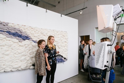 A photo booth by Smilebooth featured a custom woven backdrop by artist (and working mother) Meghan Shimek.
