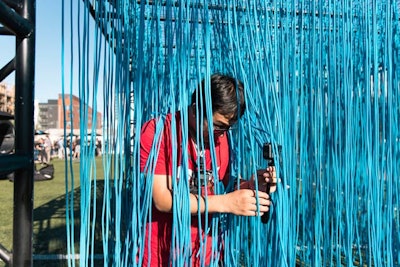 Brightly colored strings hanging from a frame provided a unique video opportunity for guests at the closing party.