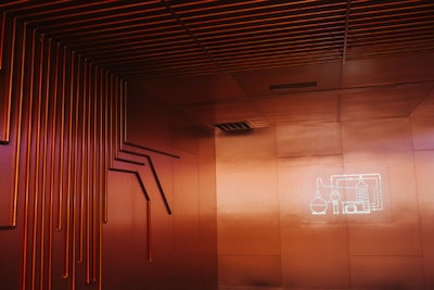 The minimalist design of the copper room was inspired by a traditional Charentais pot still, which is used to distill cognac. The room featured a neon graphic of the pot still.