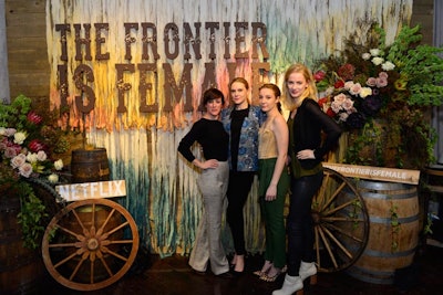 Cast members from the series posed in front of the event's step-and-repeat at a V.I.P. reception on November 16. The photo op featured wheelbarrow and barrel props, florals from Florescer NY, and signage that read 'The Frontier is Female.'