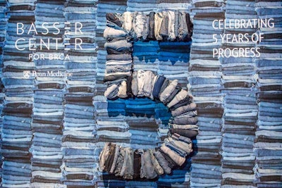 Folded denim jeans in a variety of shades were used to create a wall that was a backdrop for the event's photo booth. Jeans also were used to created a 3-dimensional number five.