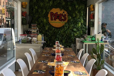Inside the truck, a wooden table, wood floors, and large windows create a casual, chic dining space.