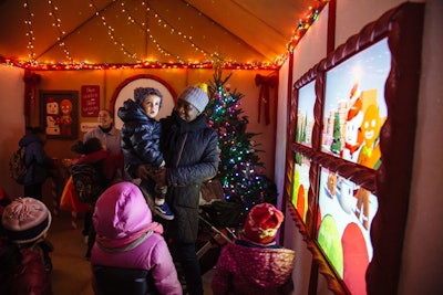 Three LED screens in the house are designed to look like windows giving a view of the gingerbread man decorating his Christmas tree.