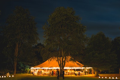 Rustic lanterns and soft, warm lighting add to the romance of this tented affair