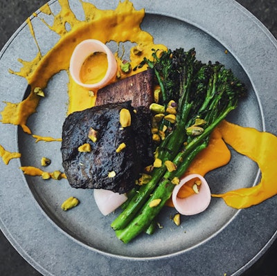 48-hour blueberry short rib, served with carrot puree, charred broccolini, pickled shallot, and pistachio, by Drake Catering in Toronto