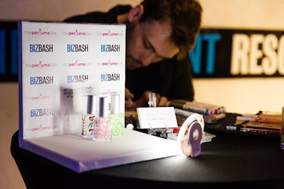 An artist personalized the perfume bottles with hand-drawn images. Then guests could arrange the bottles on a mini step-and-repeat for social media posts.