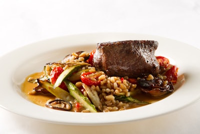 Beef tenderloin with a roasted salad of shiitake mushrooms, asparagus, cherry tomatoes, and farro and paired with a buttered mushroom soy sauce, by D’Amico Catering in Minneapolis