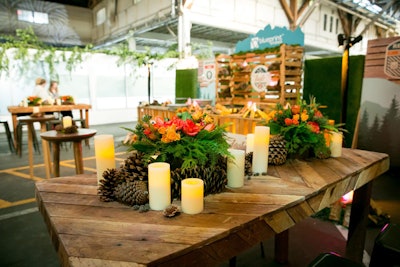On-theme centerpieces from Taste Catering & Event Planning featured warm orange and red florals with scattered pine cones.