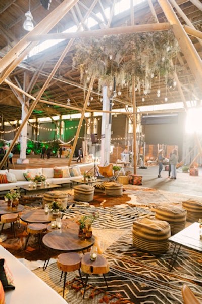 Greenery and tealights from Revel Floral hung from the structure. Shelter Company created a stylish seating area featured Southwest-inspired patterns and stools that resembled tree trunks.