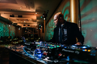 DJ D-Nice stood stationed at a green mirrored DJ booth on the dance floor, which guests passed as they entered the gala.