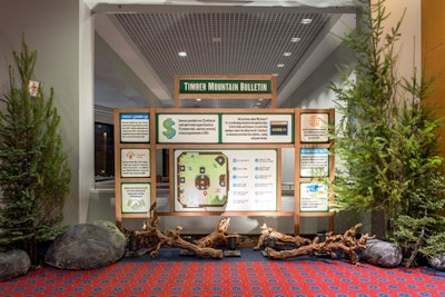 A ballroom in the Oregon Convention Center was transformed into a park-like atmosphere. At the entrance to the event, an on-theme “bulletin” detailed Comcast’s achievements and philanthropic initiatives from the past year. It was surrounded by rocks, branches, and pine trees.