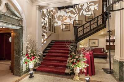 Guests at the New York event were led upstairs to the dinner after the cocktail portion. Design elements included floral wall projections.