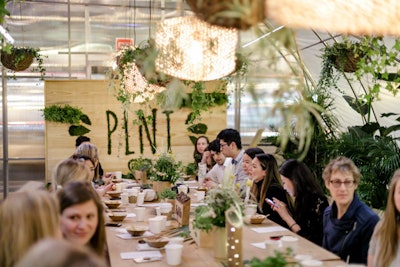 The space was designed to mimic the feel of a greenhouse, complete with hanging garden lights, sod flooring, and plants as table decor.