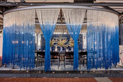 Partnering with the Rug Company, Rockwell Group created an elliptical curtain made of 400 strands of hand-dyed, blue ombre carpet fibers, showcasing the Lola rug that is specially designed by David Rockwell and his daughter Lola.