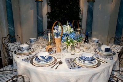 Inspired by the courtyard at Ralph’s restaurant in Paris, the Ralph Lauren tablescape featured wicker wine coolers and summery shades of blue.