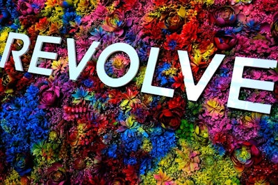 At the 2017 Revolve Festival, held at the Merv Griffin Estate in Indio during Coachella weekend, a photo backdrop included a bold logo against a vibrant tie-dye-like succulent wall.