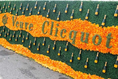 The ninth annual Veuve Clicquot Polo Classic took place in June 2016 at Liberty State Park in New York. A floral wall used greenery to spell out the brand’s name and surrounded it with orange flowers and bottles of the champagne.