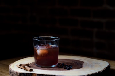 Coffee grounds infuse flavor into the vermouth in the Old Brew, New Tricks cocktail, which also contains Patron Reposado tequila, cynar, Ancho Reyes liqueur, and two dashes of mole bitters.
