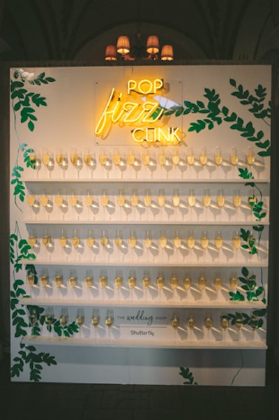 After entering the venue, guests could grab glasses of champagne from a wall with an on-theme neon sign.