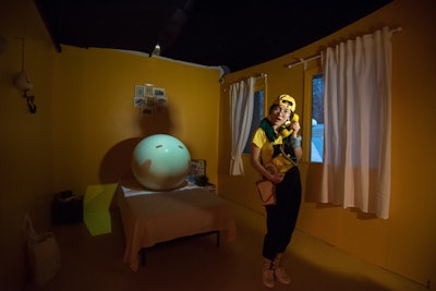 The story of Ellis the Egg is most notably brought to life in a yellow room that depicts the character's bed room. A giant egg prop opens and closes its eyes with projection technology created by Objectseen. The room also has 'windows' which display a video of people walking in Washington Square Park.
