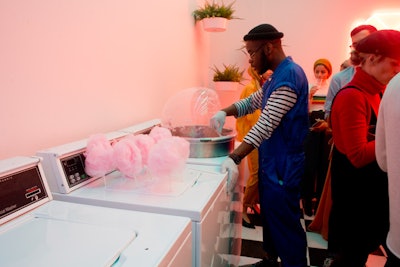 Blessed Kabasu, a New York-based actor, served guests cotton candy out of washing machines. Kabasu was one of a number of staffers dressed as 'dream technicians,' who wore blue uniforms at the museum's media preview.