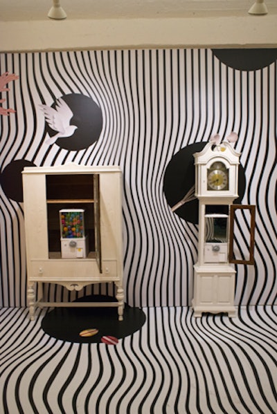A black and white living room space features a gum ball machine where guests can retrieve egg-theme prizes by using a customized coin they receive at the entrance.