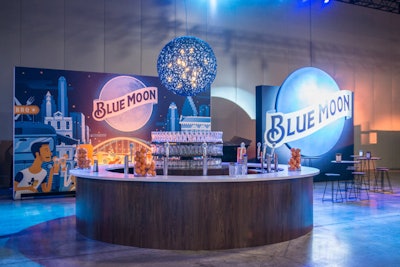 The Blue Moon bar went literal with the brand name, displaying an illustrated backdrop in blue and orange colors that depicted downtown Austin at night. The bar showcased oranges in vases and the brand’s signature glasses. An illuminated blue moon was suspended over the bar.