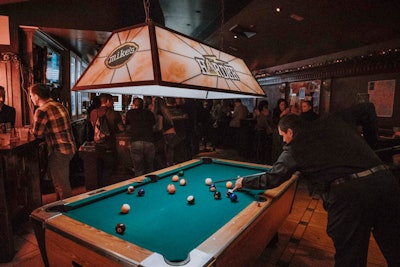 A pool table for guests was lighted by an overhead lamp that displayed the Mike’s Harder logo.