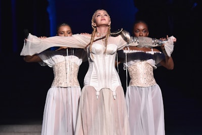 Following dinner, Madonna, initially wearing a monastic cloak, descended the stairs of the Great Hall and made her grand entrance on the stage to the tolls of church bells. Fittingly, she opened her set with 'Like a Prayer' and segued into 'Hallelujah' as she walked through the crowd.