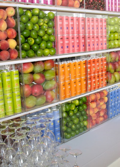 For a party at a spa, Chicago-based designer Debi Lilly created a colorful bar backdrop using Nutrisoda cans stacked in acrylic cubes with color-blocked fresh fruit.